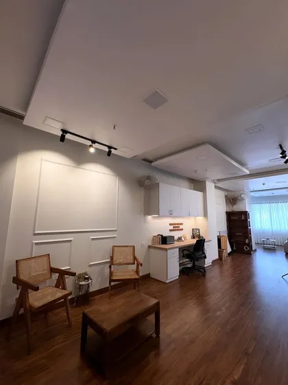 A wide view of the studio, showing the versatile space with its different setups, from the living room area to the workspace.