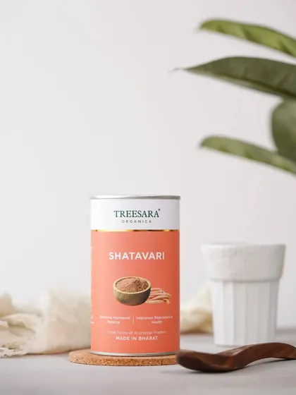 A clean, bright shot of Shatavari powder, an immunity booster. The plant in the background adds a touch of nature.
