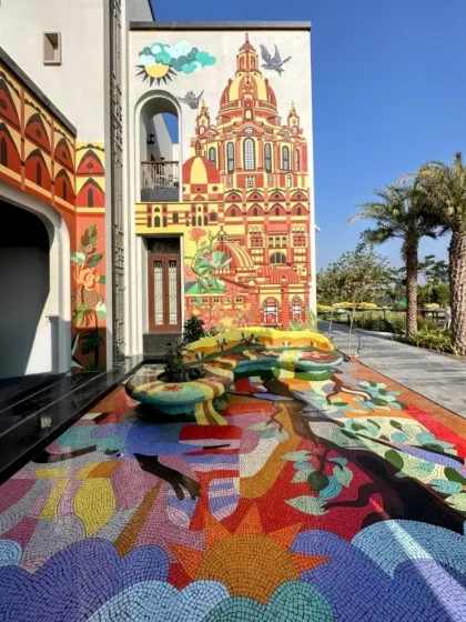 We believe art should be an experience that consumes you, not just something you hang on a wall. For this residential project in Rajkot, we turned an entire entrance volume into a vibrant labyrinth, starting with a custom mosaic floor that flows into a functional art bench and climbs up the facade in a hand-painted mural. This is what we mean when we say we turn spaces into stories.