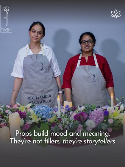 Two students collaborate on a large table runner. Props like candles build mood and meaning, turning a simple arrangement into a storytelling piece, a great lesson for group event styling.