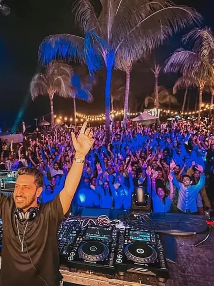 This is the view from my console in Mauritius, a sea of energy under the palm trees. It's moments like these, connecting with thousands of fans and feeling the collective joy, that define my performances at large-scale concerts and festivals.
