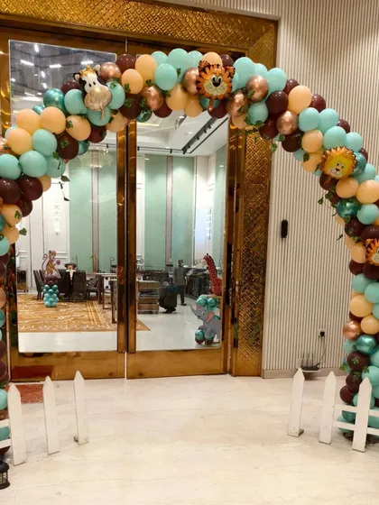 A grand balloon arch at the entrance to the party hall, setting the stage for the jungle adventure inside.
