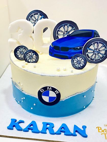 For the ultimate car enthusiast, a BMW-themed cake. This design features the iconic logo, wheels, and a cool blue and white color scheme.