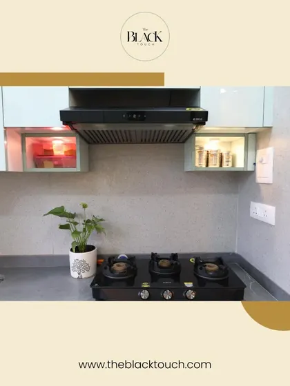 A well-organized kitchen with a sleek black chimney and hob. The design includes practical elements like lift-up cabinets and under-cabinet lighting to make the cooking process smoother.