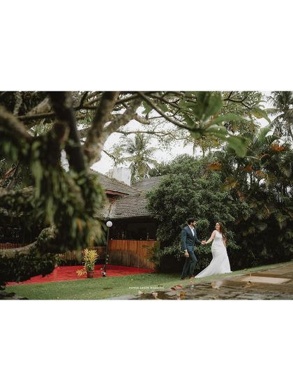 A wide, cinematic shot of the couple in a beautiful resort setting, capturing the scale and romance of their wedding day.