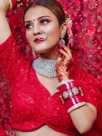 A modern bride in a red sequin blouse, wearing a stylish diamond choker. The red choora adds a traditional touch to this contemporary look.