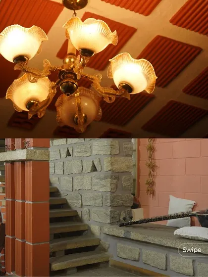 A combination of an ornate chandelier against a filler slab ceiling and a built-in stone seating area, showing the blend of traditional and modern elements.