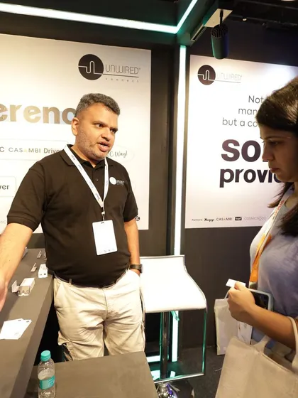 An exhibitor from Unwired Connect explains their smart lighting driver technology to a visitor, showcasing the in-depth technical expertise available on the show floor.