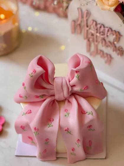 A close-up of the stunning pink bow cake from my Mother's Day 'Bloom Box'. The hand-painted floral details on the edible bow make this cake a true work of art.