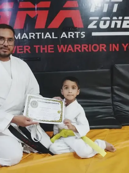 This young boy has successfully passed his belt test and is awarded his yellow belt by our sensei.