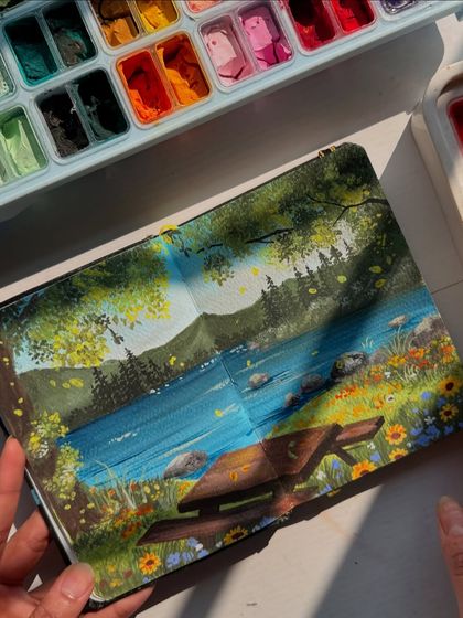 Holding the sketchbook open to the picnic painting. It feels like a little window into a peaceful, sunny afternoon.