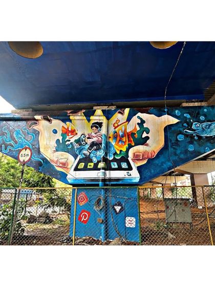 For this bridge pillar, the theme was digital creativity. The mural shows hands holding a tablet from which a world of art and imagination emerges, including sea life and abstract shapes.