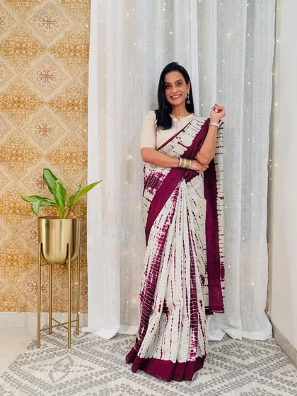 A beautiful shibori-style tie-dye saree in white and maroon. This is a unique and stylish workwear saree that is both comfortable and eye-catching.