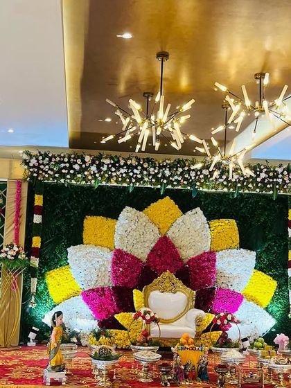Another perspective of the grand Seemantham stage with the multi-colored floral lotus. This view shows the scale of the decoration within the event hall, making it a truly impressive centerpiece.