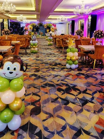 The details extend throughout the venue. For this jungle party, I created small balloon columns topped with monkey and giraffe foil balloons, placing them around the seating area to continue the theme and delight the young guests.