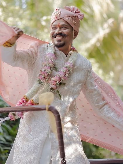 A groom enjoying his baraat, his pink dupatta flying in the wind.