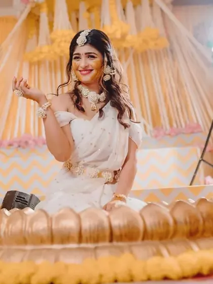 The beautiful bride-to-be at her Haldi ceremony, seated in the custom golden lotus tub we fabricated for her special day.