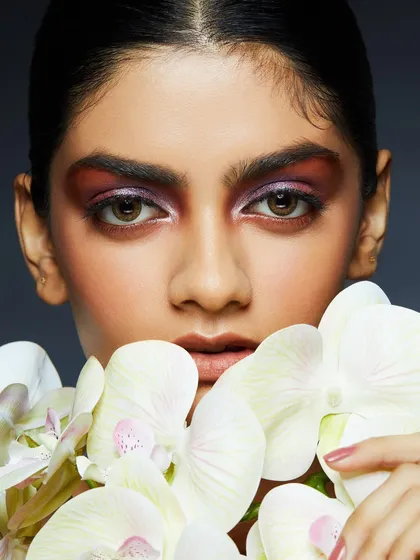 A soft, romantic look with a wash of purple eyeshadow, beautifully complemented by white orchids.