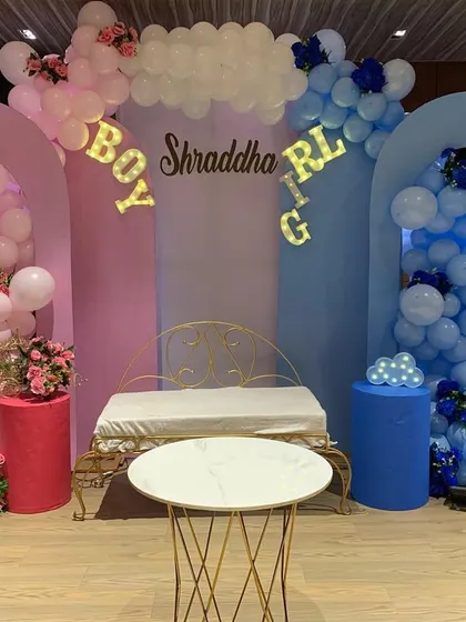A 'Boy or Girl' themed baby shower decor. We used pink and blue arched backdrops with matching balloon cascades to create a fun and stylish gender reveal setup.