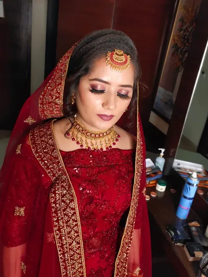 A close-up of the bride's makeup, showing the soft pink eyeshadow and defined brows that complete her reception look.