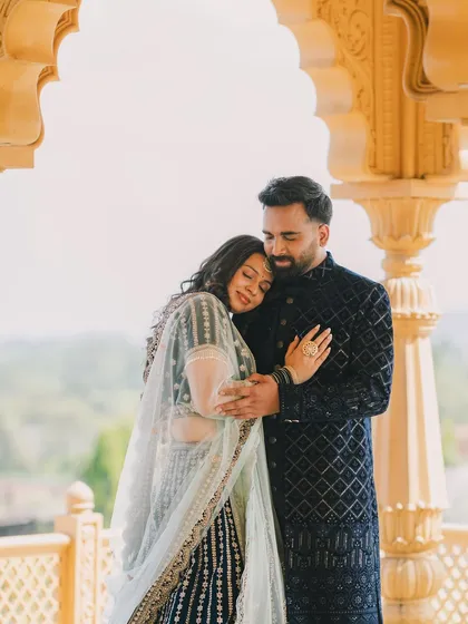 A tender moment shared between a couple under an ornate archway, showcasing a soft and romantic photography style for pre-wedding shoots.