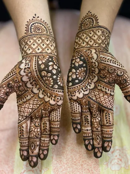 A classic design with a large floral mandala at the center of the palm, surrounded by a mix of traditional Indian mehandi patterns.