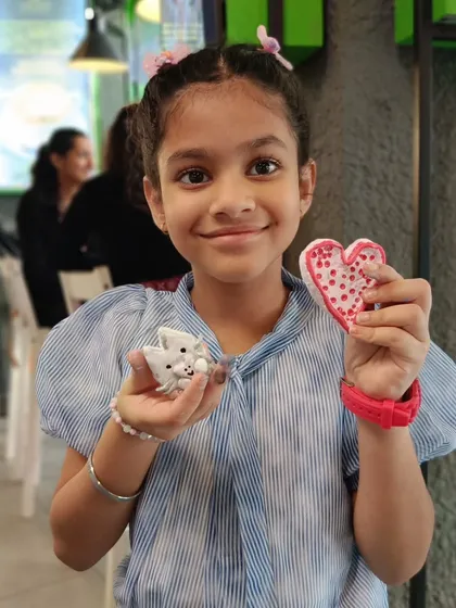 A young participant proudly shows off her handmade clay cat and heart. Our workshops are a great way for kids and adults to spend a weekend.