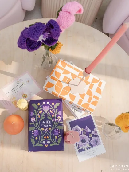 A flat lay of the beautiful, custom-designed stationery and favors for the "Bloom" wedding, showcasing a cohesive and artistic theme.