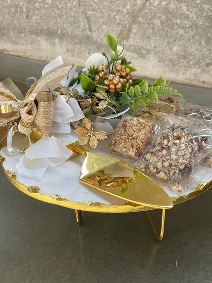 A beautiful gift hamper created using our white marble cake stand with gold-leafed edges. We’ve added a golden server and gourmet treats, wrapping it all with a festive bow for a truly special present.