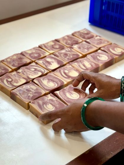 These are our custom Sweet Rose artisan soaps on the stamping table. The beautiful purple and cream swirls are a signature of this bestselling bar.