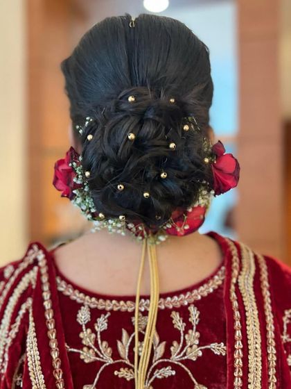 A full view of the textured floral bun, showcasing the placement of roses and baby's breath for a balanced and beautiful design.