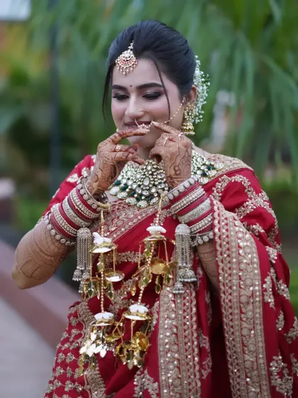 A playful moment with the bride adjusting her nath, her happiness shining through.