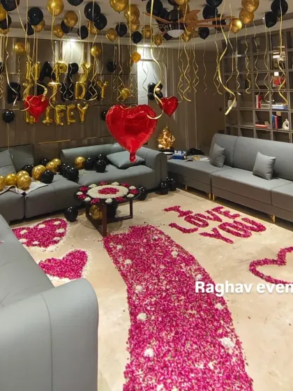 I can turn any room into a romantic surprise for your wife's birthday. This decoration features a pathway of rose petals leading to a cozy setup with 'Happy Birthday Wifey' foil balloons, and a mix of black and gold balloons for a classy look.