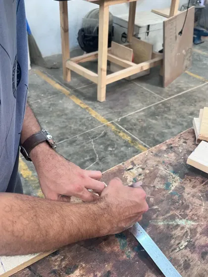 It all starts with a plan. A participant carefully measures and marks his pine wood, getting ready to make the first cut. Precision is key, and we teach you how to get it right.