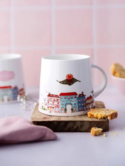 A clean and simple product shot focusing on a Theobroma illustrated mug. The soft pink background and carefully placed biscotti create a sweet, charming composition that highlights the unique design of the merchandise.