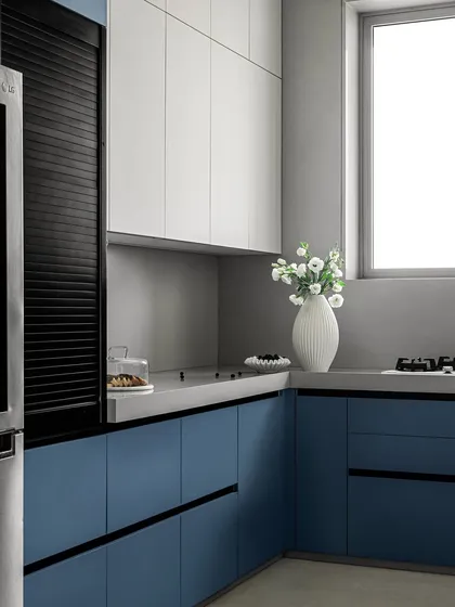 Another view of the matte blue and white kitchen. The clean lines, handle-less drawers, and integrated appliances contribute to the sleek, minimalist aesthetic.