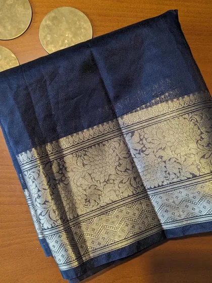 A closer look at the black Kora Organza saree, showing the intricate floral design on the wide zari border.