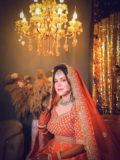 A classic seated portrait that showcases the bride's full attire against the elegant wedding decor.