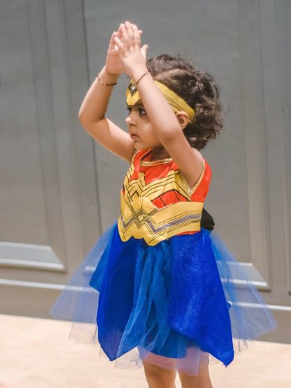 Our little Wonder Woman striking a pose. We love incorporating fun themes like superheroes into our classes to spark imagination.