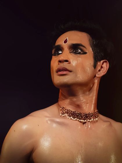 A close up shot capturing the emotion and intensity of a performance. The detailed makeup, including the bindi and eye-liner, is traditional and helps accentuate facial expressions.