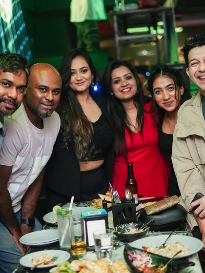 A group of friends enjoying food and drinks at their table.