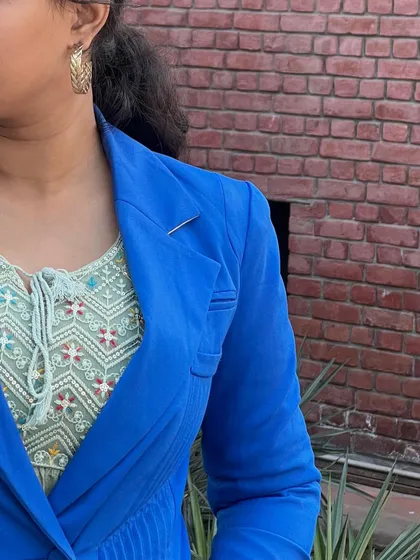A detail shot of the layering in my chic western outfit. You can see the texture of the embroidered inner top against the smooth fabric of the royal blue blazer.