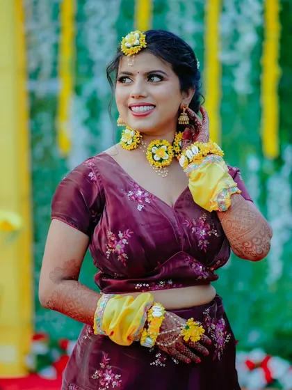 A beautiful portrait of the bride in her Haldi outfit, adorned with stunning yellow floral jewelry.
