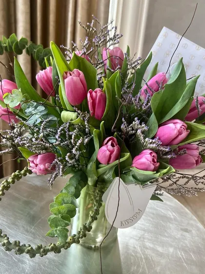 These beautiful pink tulips, sourced from Holland, epitomize deep love. This arrangement showcases their elegant form, paired with delicate filler flowers and eucalyptus, to let their beauty shine.