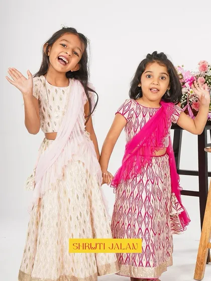 Happy girls are the prettiest. These two sisters are beaming in their printed lehengas, one in cream and pastel pink, the other in a vibrant fuchsia.