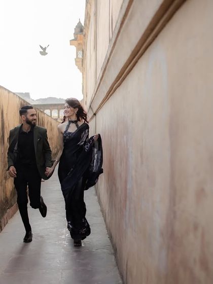 A playful run through the narrow lanes of a fort, a moment of pure, unscripted joy. We love capturing these dynamic shots that bring energy and life to your pre-wedding album.