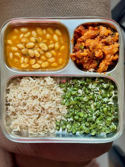 A plate with brown rice, soya bean curry, egg bhurji, and sautéed beans. This meal is packed with both plant-based and animal-based protein.