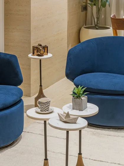 The details make the design. This lounge corner in the 'Terra Office' director's room shows how bold color, like these blue velvet chairs, and curated decor can create an inviting space for informal meetings or quiet reflection.