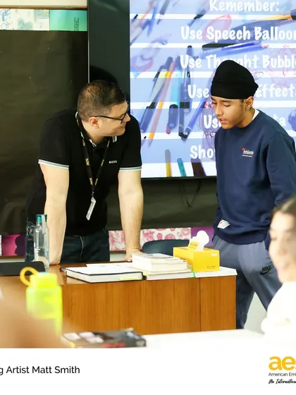 A visiting artist provides one-on-one guidance to a high school student. These personalized interactions are invaluable for students looking to deepen their artistic practice.