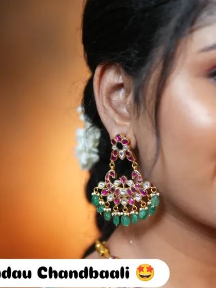 Sometimes, the right pair of earrings is all you need to complete your look. These exclusive Jadau Chandbaali earrings, with their intricate kundan work and colorful ruby and emerald stones, are a statement piece on their own.